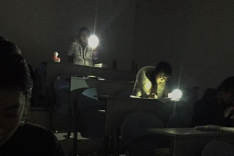 青岛一高校停电 考生在手机电筒灯光下答卷-新